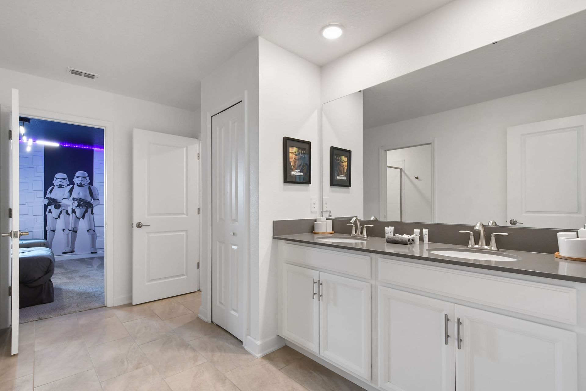 Spacious bathroom with double sinks, sleek design, and a peek into themed fun.
