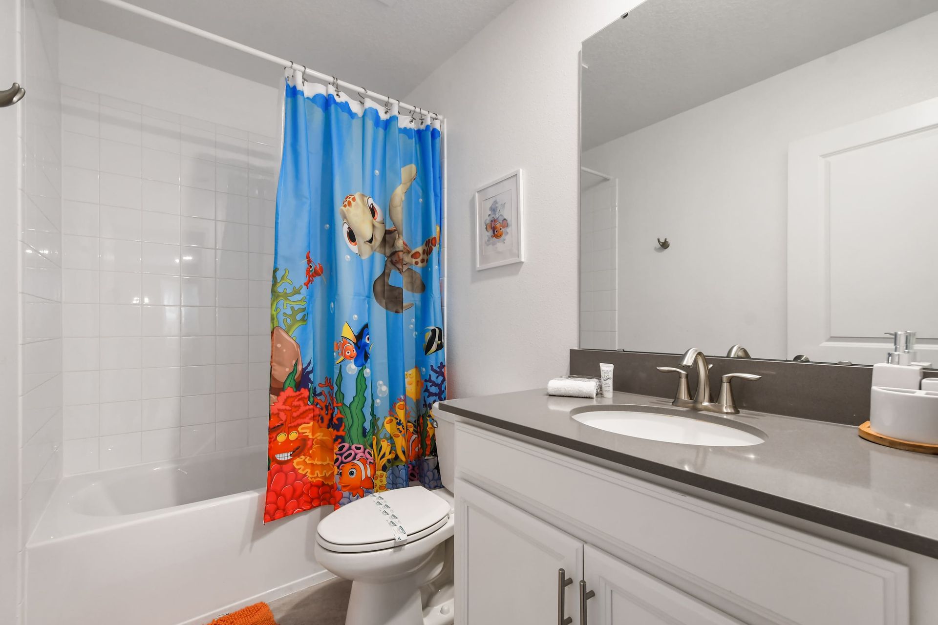 Fun ocean-themed bathroom with bright decor, full tub, and kid-friendly charm.
