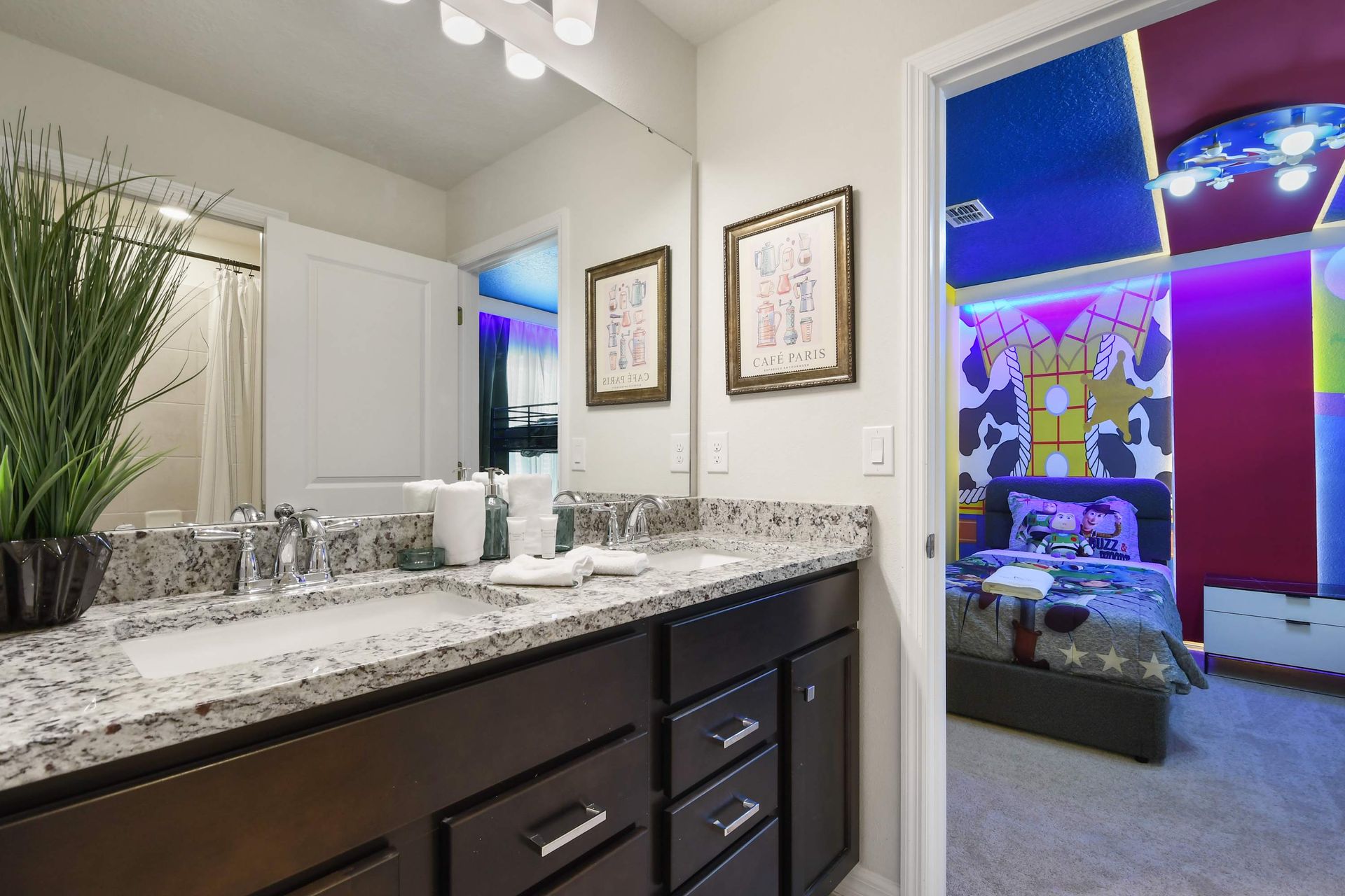 Modern bathroom with granite vanity, steps from themed bedrooms.