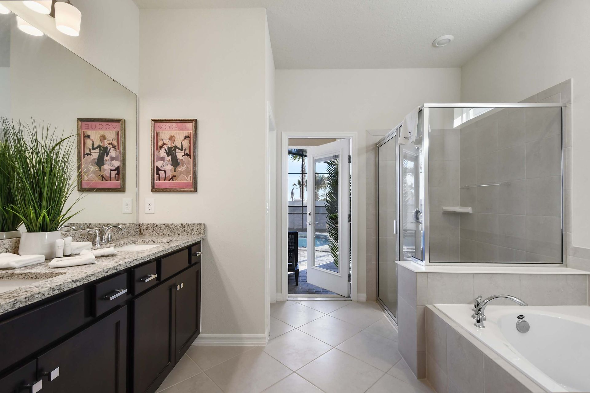A spacious and elegant bathroom featuring a double vanity, granite countertops