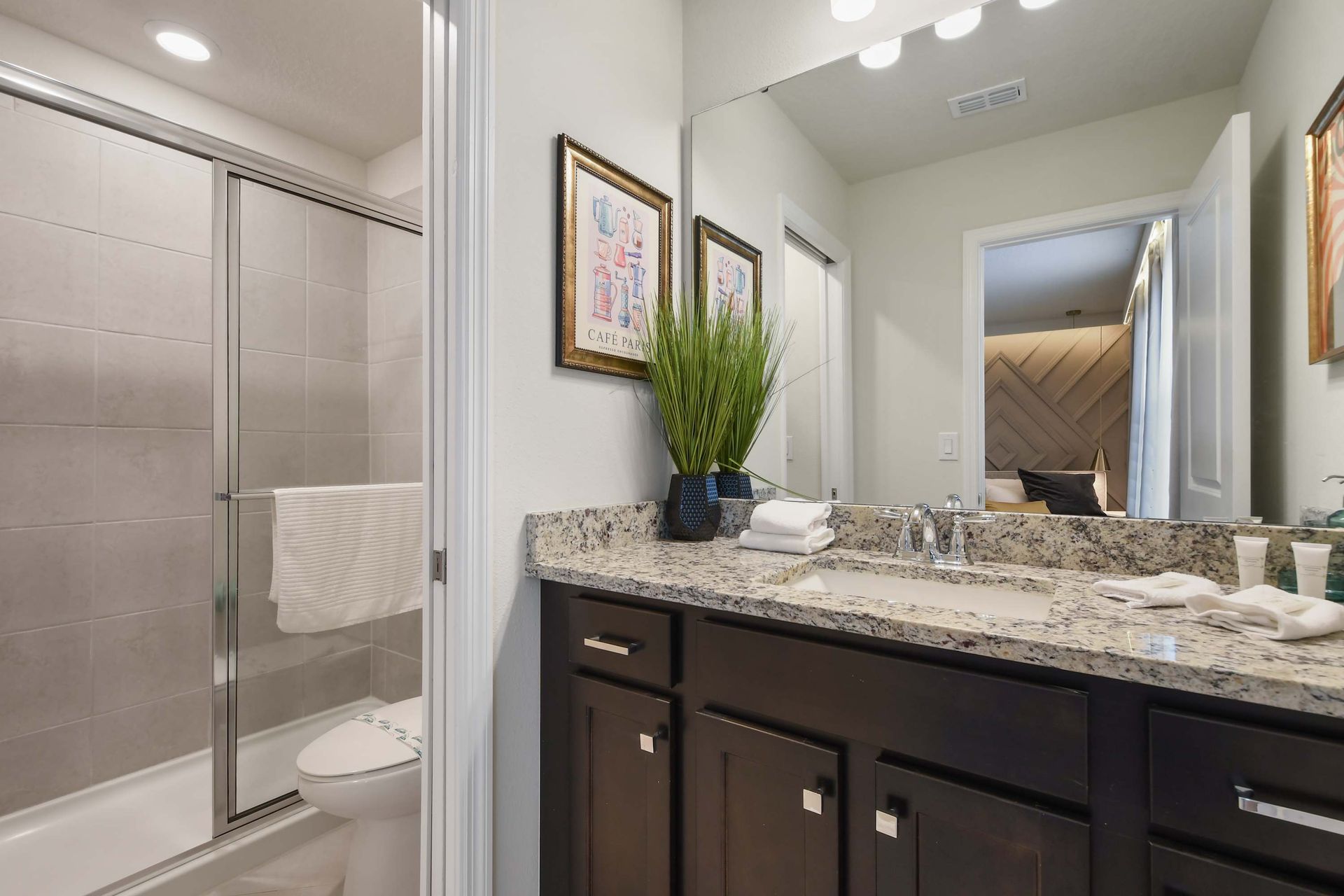 Bright bathroom with granite vanity and walk-in shower.