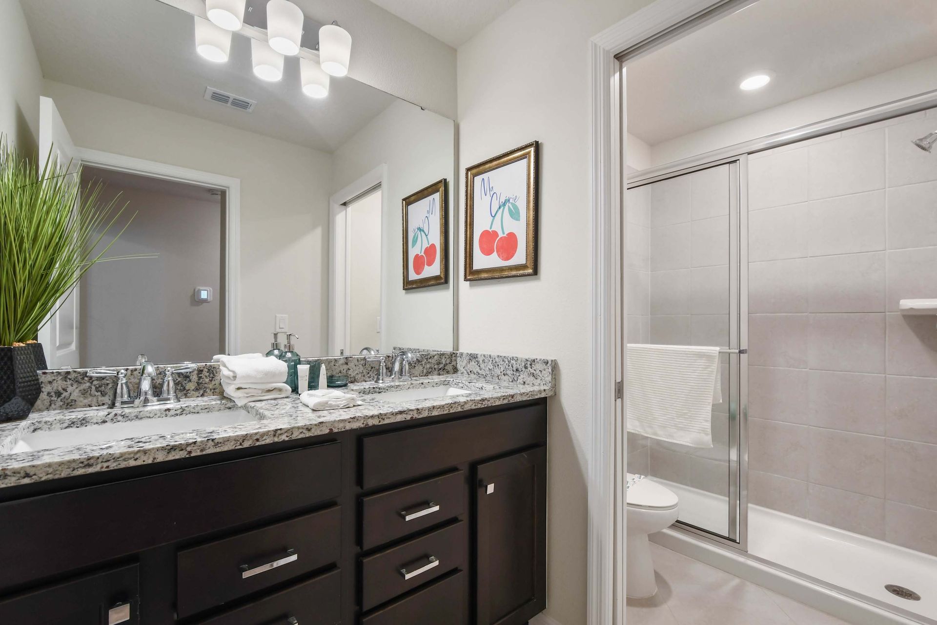 Modern bathroom with granite countertops and sleek walk-in shower.