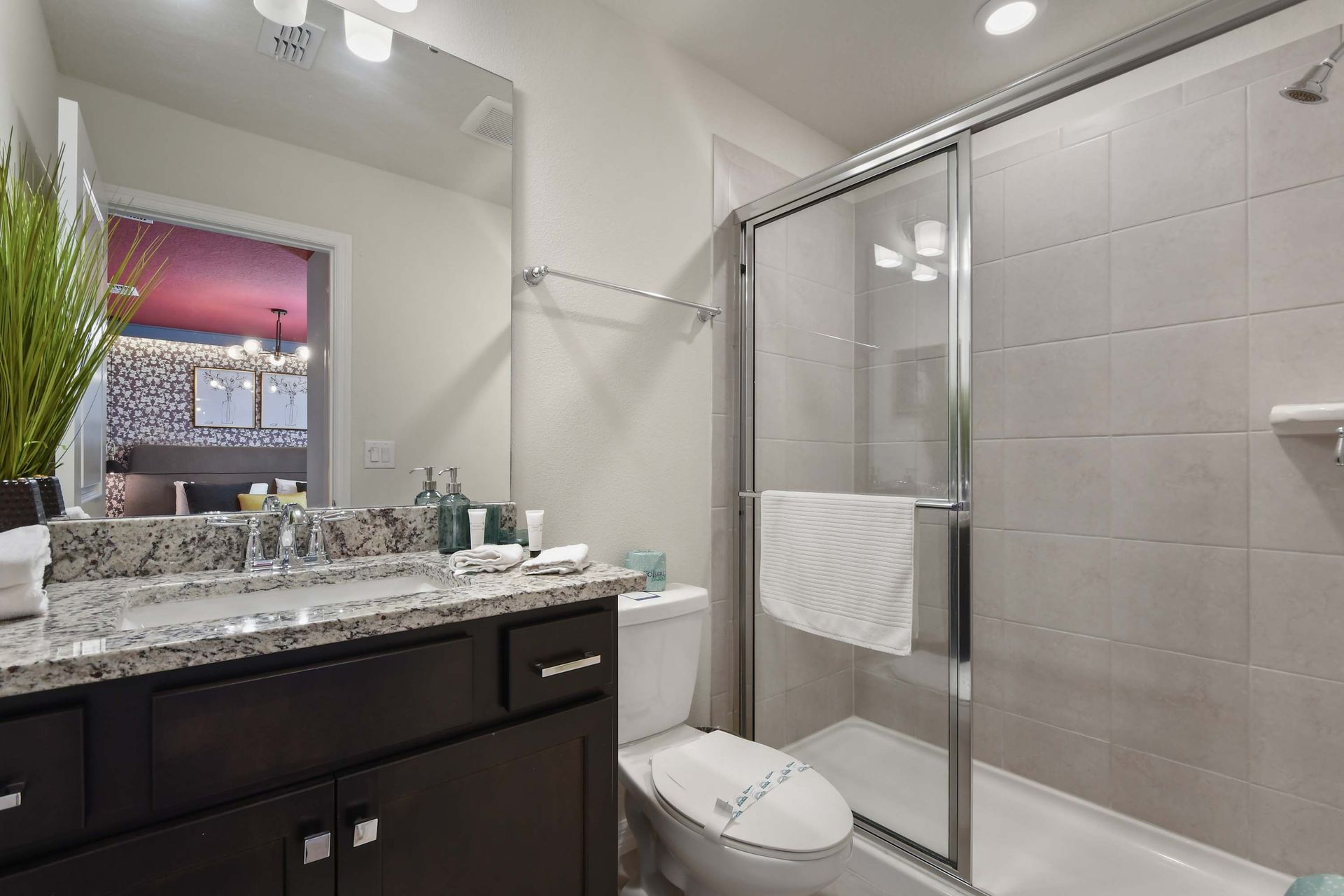 Modern bathroom with granite vanity and private themed room access.