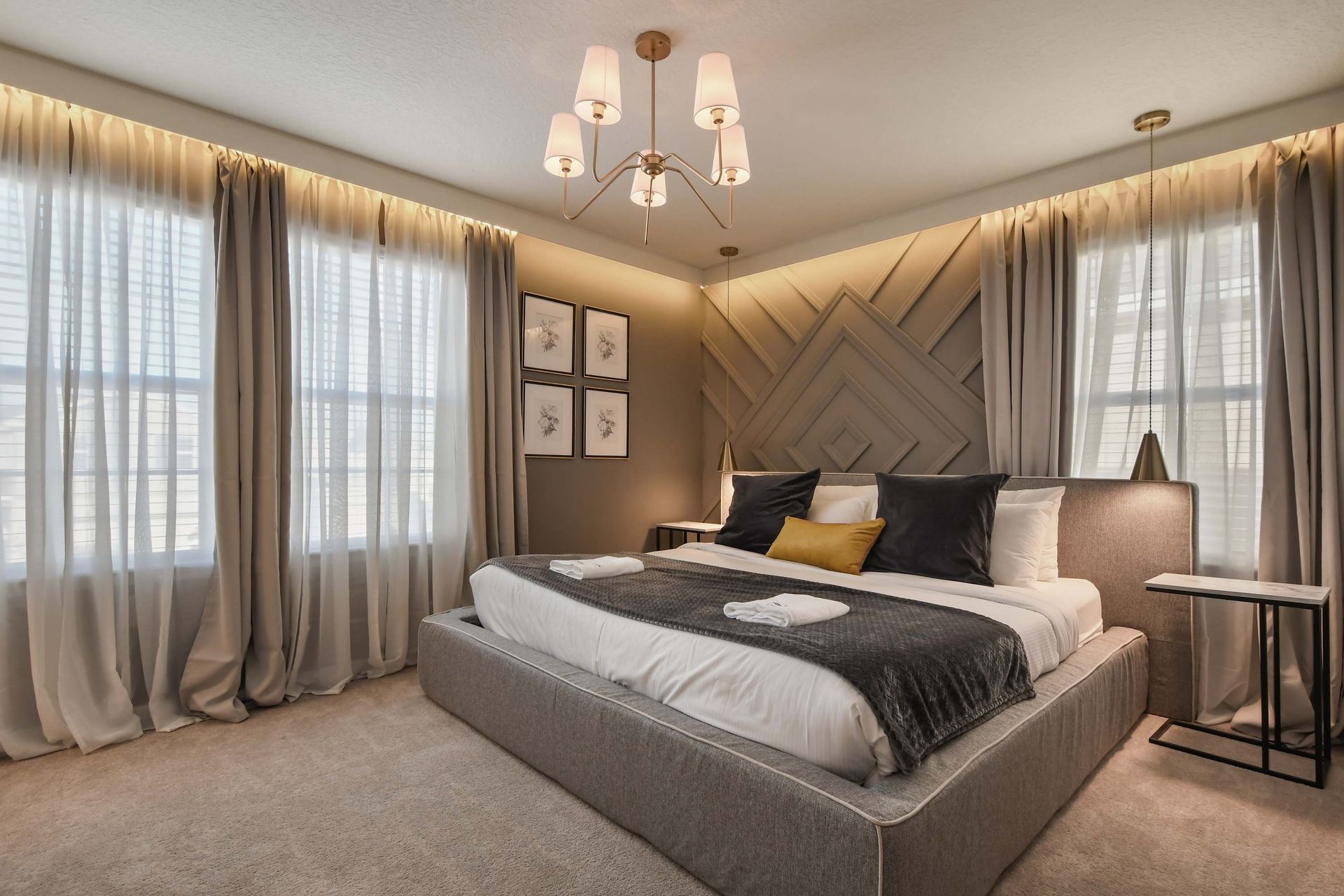 Modern luxury bedroom with geometric accent wall and cozy ambiance!