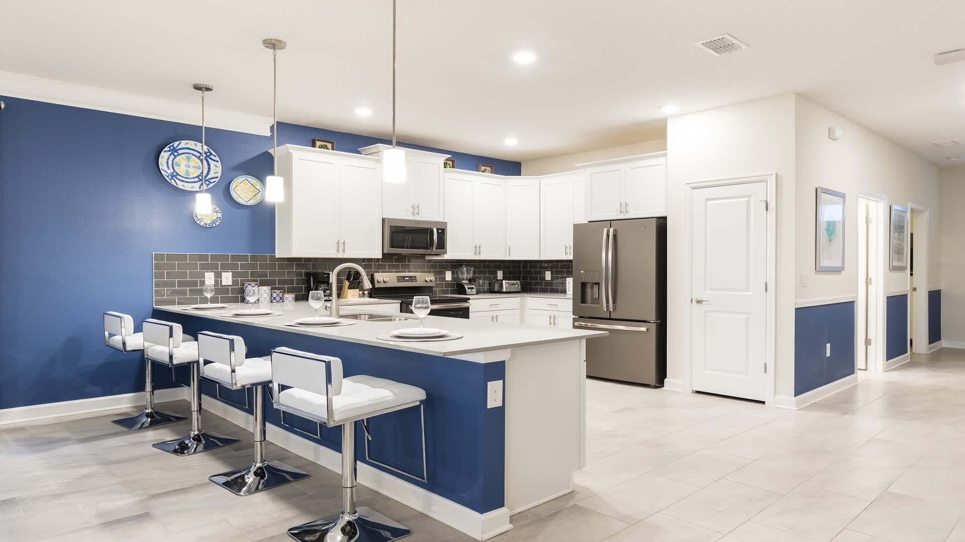 Stylish open kitchen with bar seating, stainless appliances, and modern finishes.