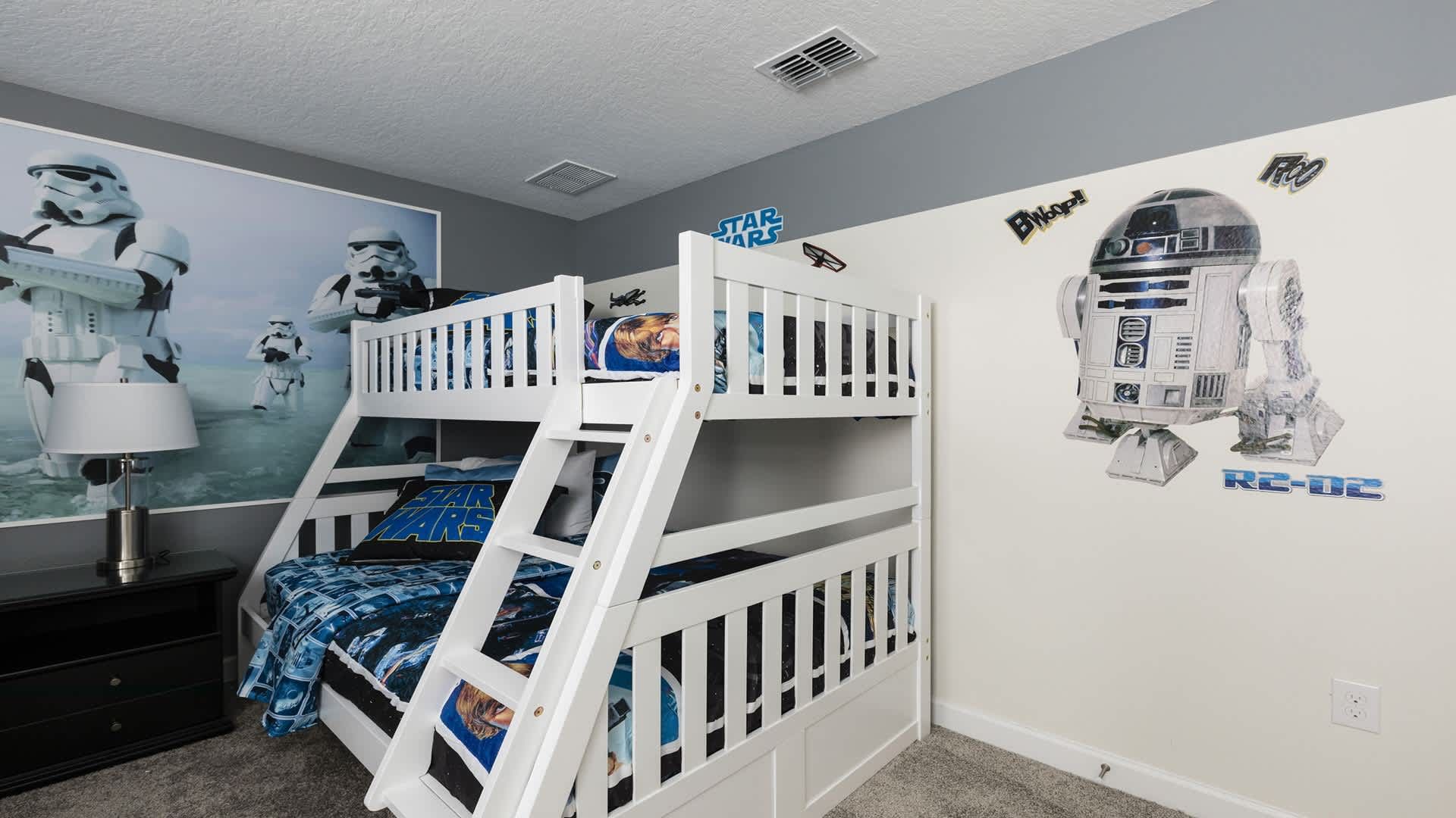 Star Wars themed bunk room with R2-D2, stormtroopers, and galaxy bedding.