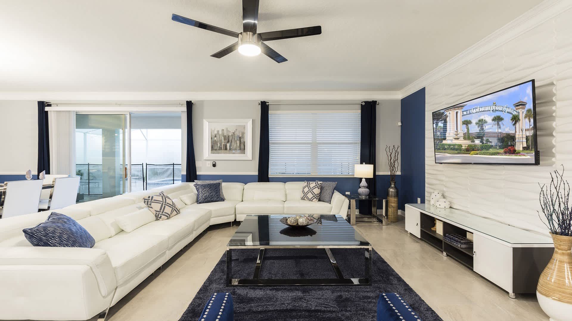 Bright and modern living room with large sectional, smart TV, and stylish decor.