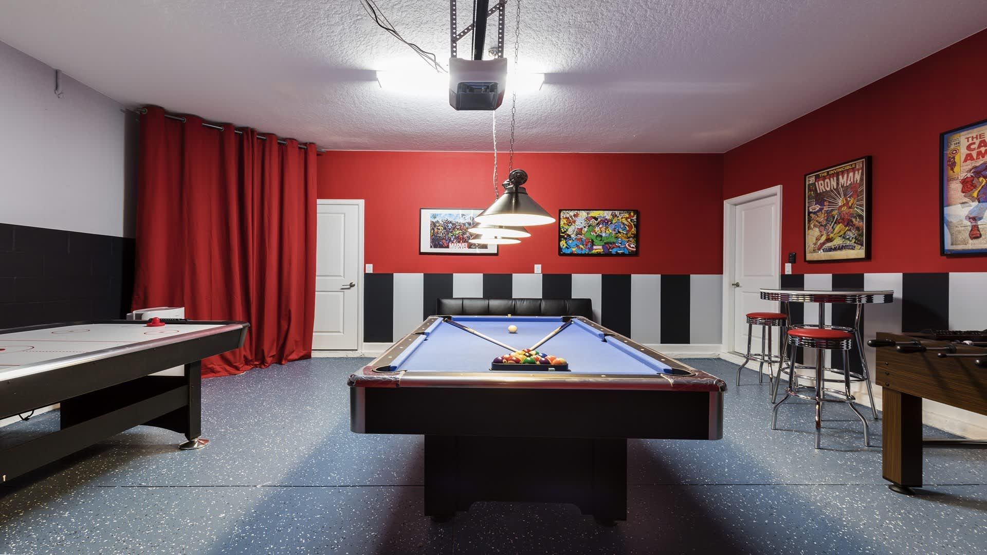 Game room with pool, air hockey, foosball, and bar seating for endless fun.