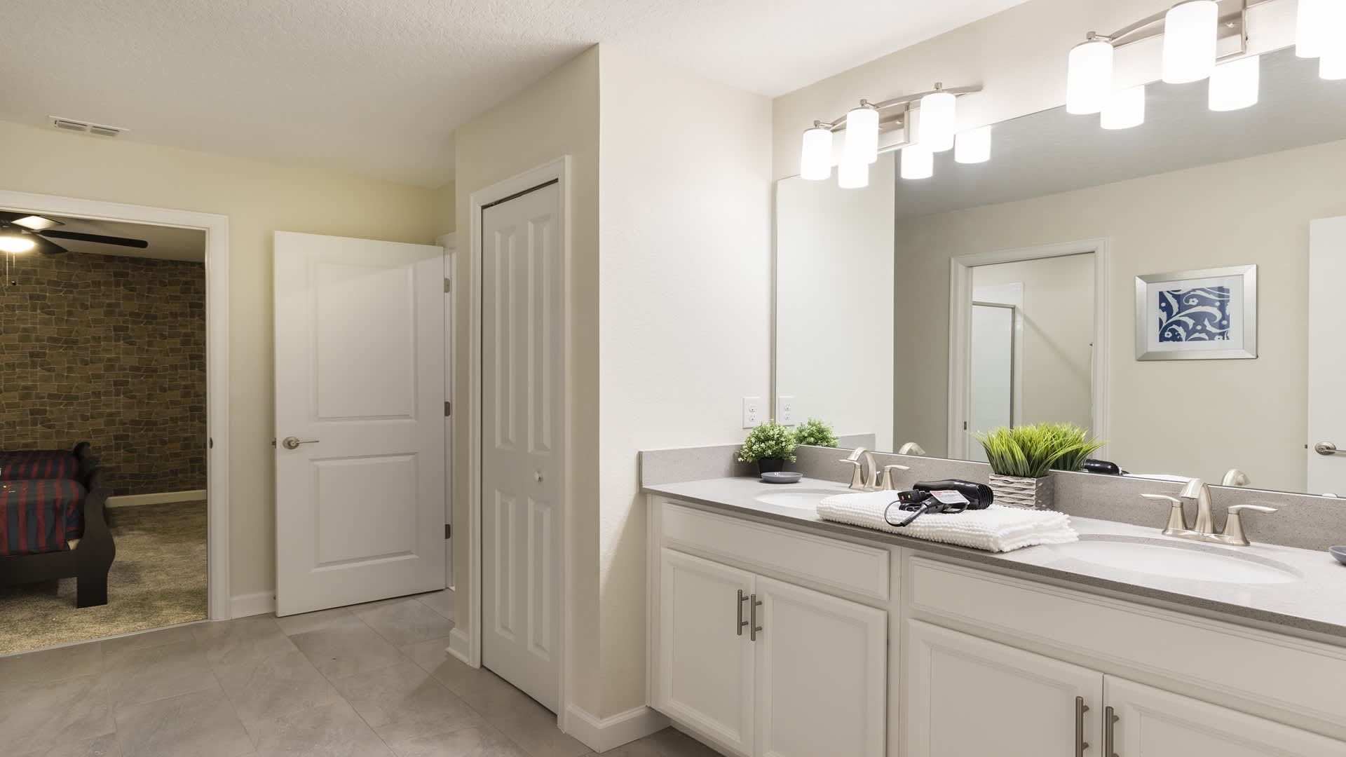 Spacious bathroom with double sinks, bright lighting, and modern clean design.