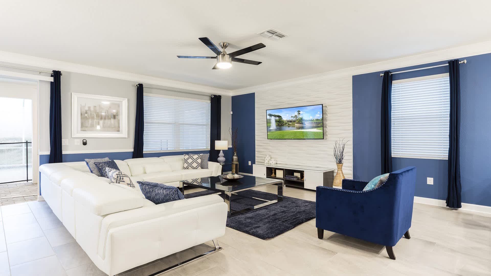 Spacious living room with sleek decor, comfy seating, and large smart TV.