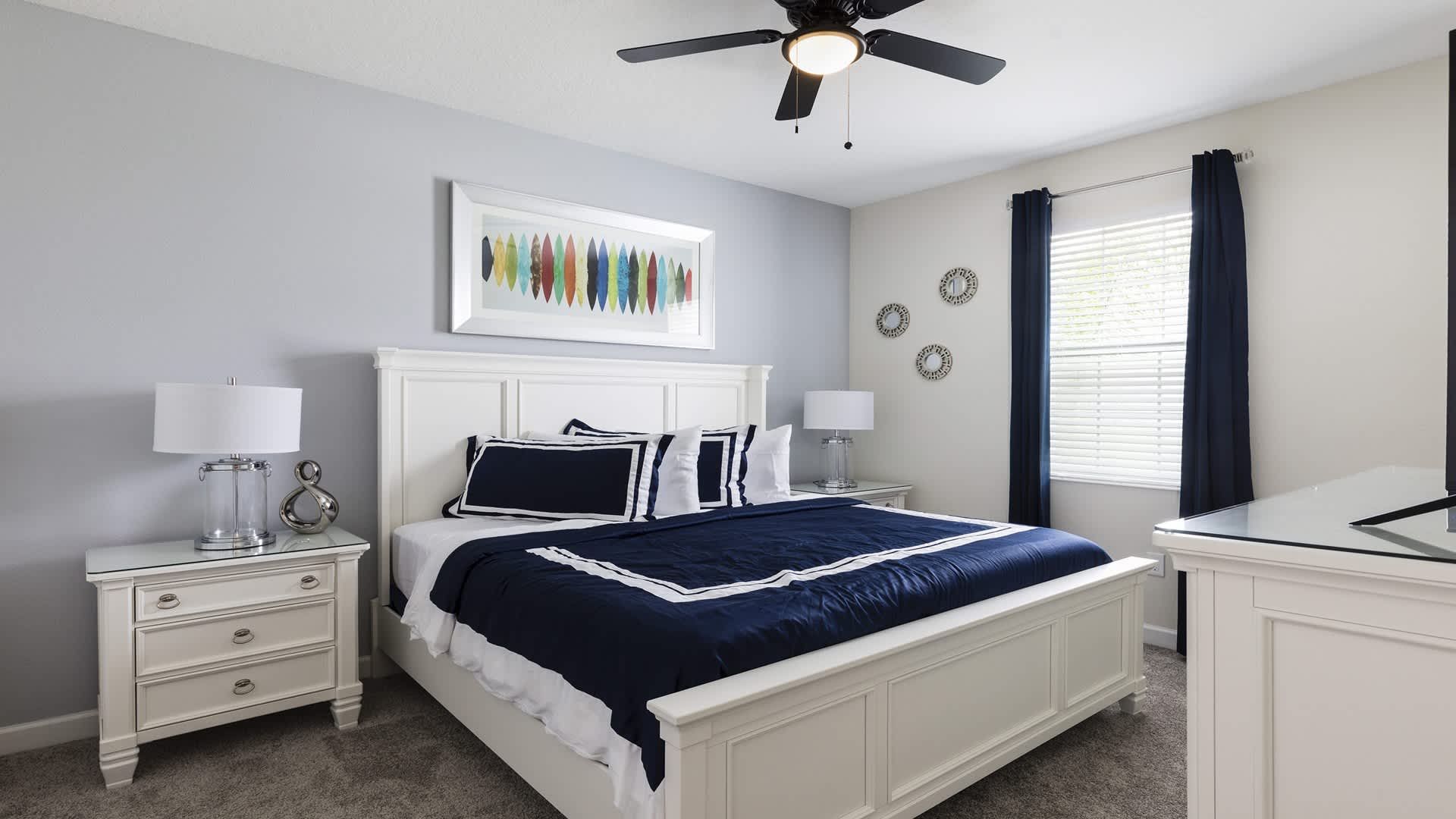 Bright and inviting king bedroom with bold navy accents and modern elegant décor.