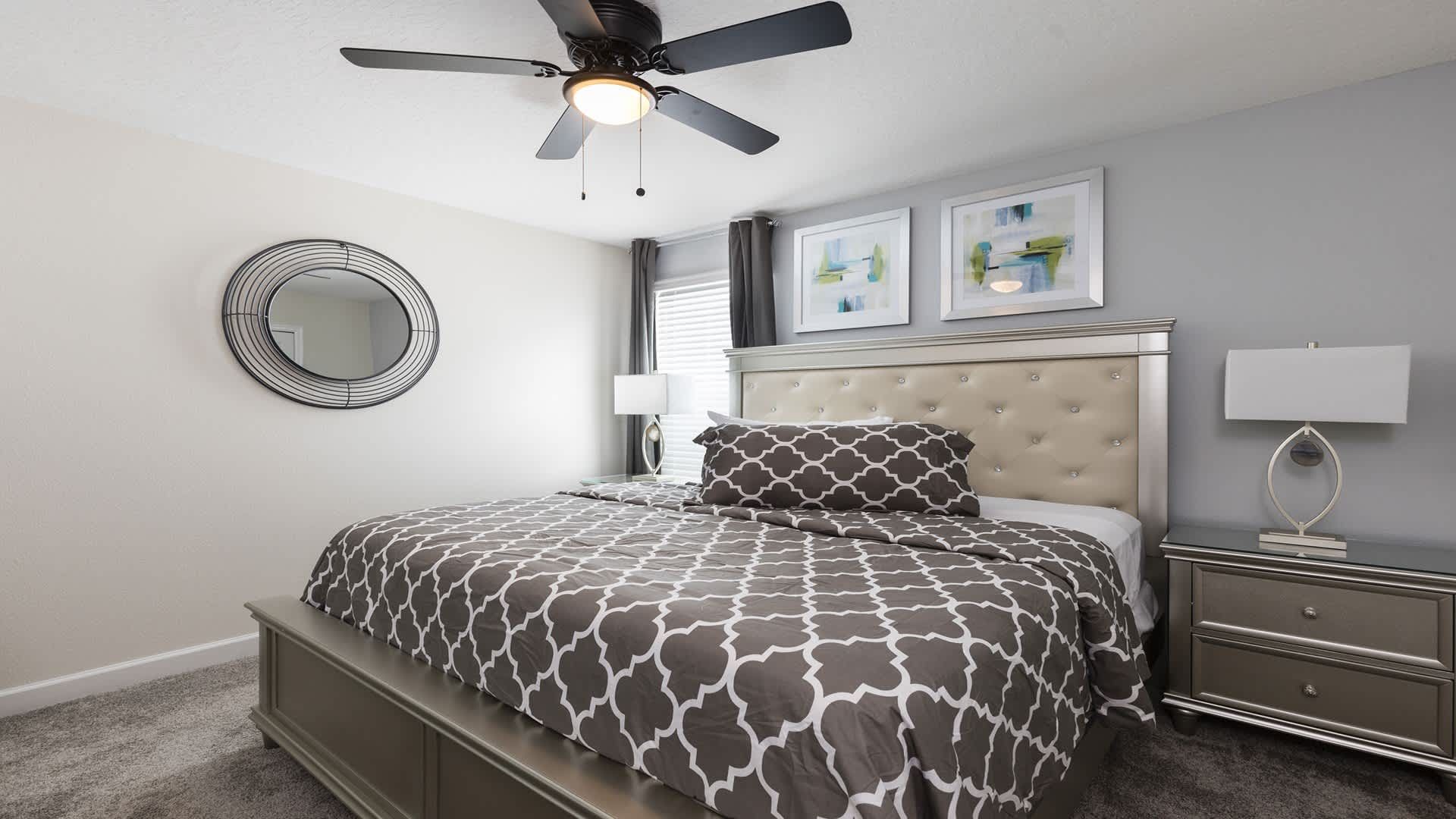 Stylish king bedroom with plush bedding, silver accents, and calming tones.
