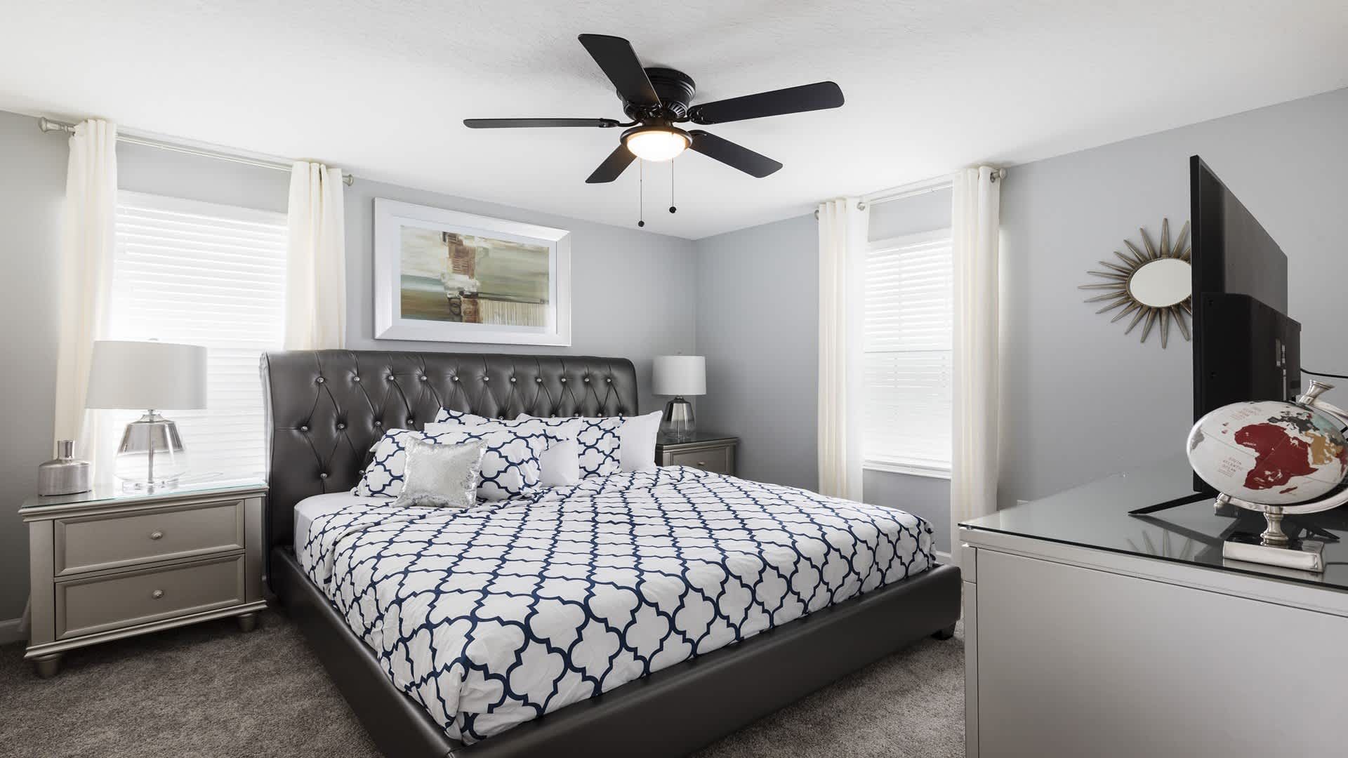 Elegant king bedroom with soft lighting, plush bedding, and modern decor touches.