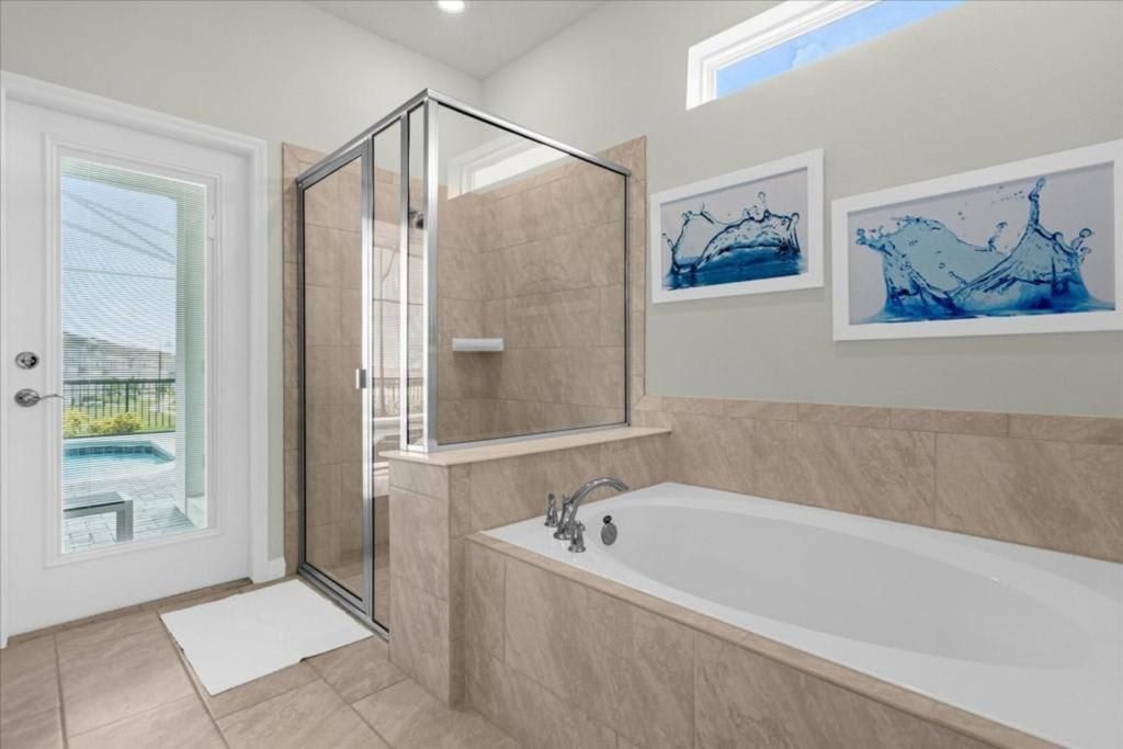 Luxurious bathroom with soaking tub, walk-in shower, and private door to the pool.