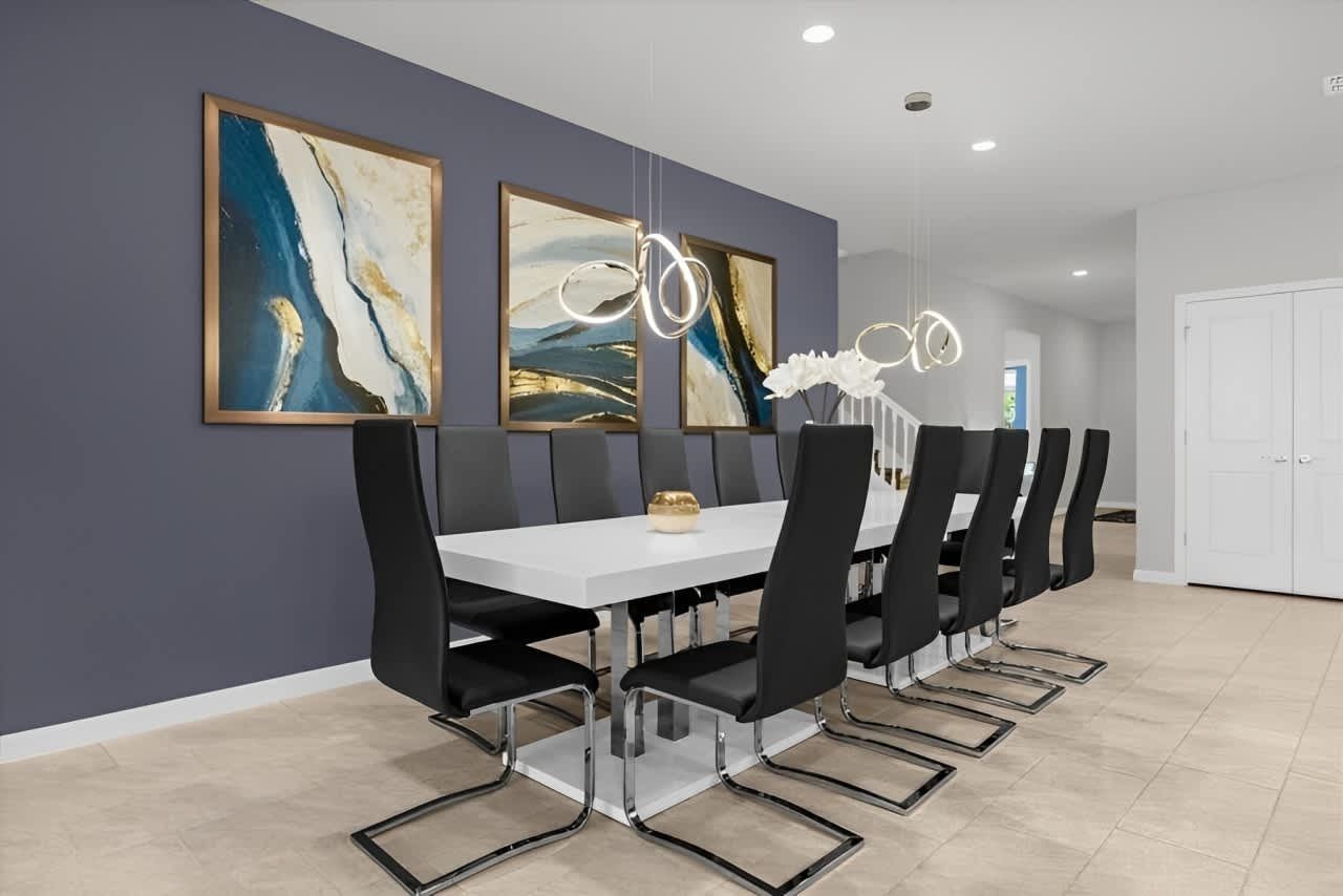 Elegant dining area with seating for 12, modern lighting, and bold abstract art.