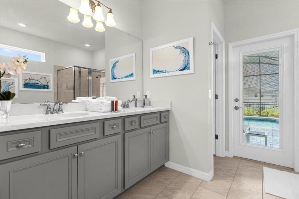 Elegant bathroom with dual sinks, walk-in shower, and direct access to the pool area.