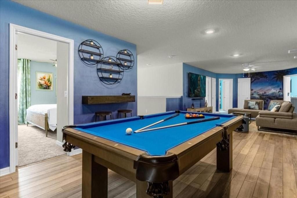 Spacious game room with pool table, lounge seating, and vibrant themed decor.