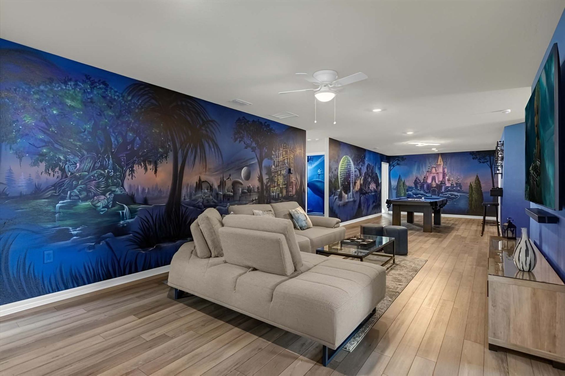 Enchanting themed lounge with custom wall murals, plush seating, and game table fun.