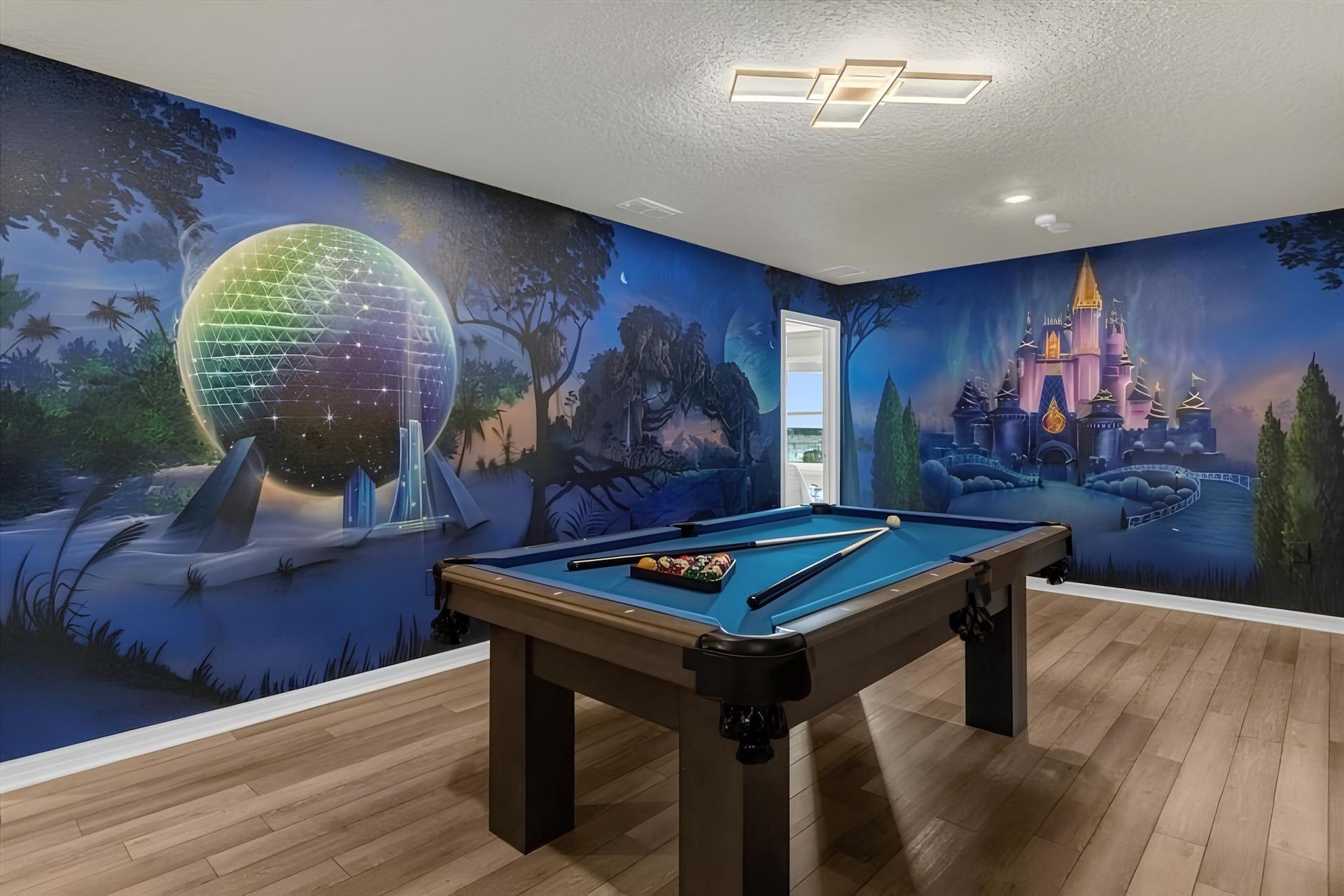 Magical game room with pool table and stunning theme park-inspired wall murals.