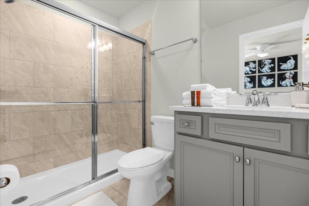 Stylish bathroom with sleek gray vanity, glass-enclosed shower, and modern finishes.