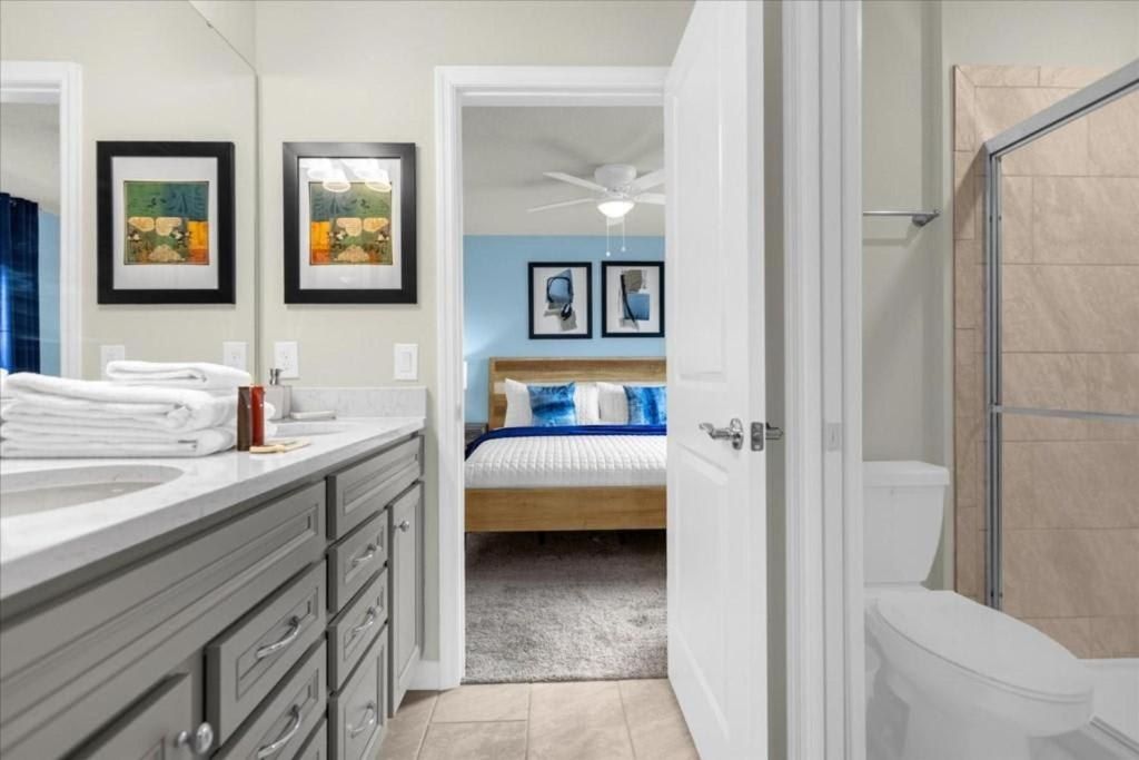Modern Jack-and-Jill bathroom with dual sinks, walk-in shower, and bedroom access.