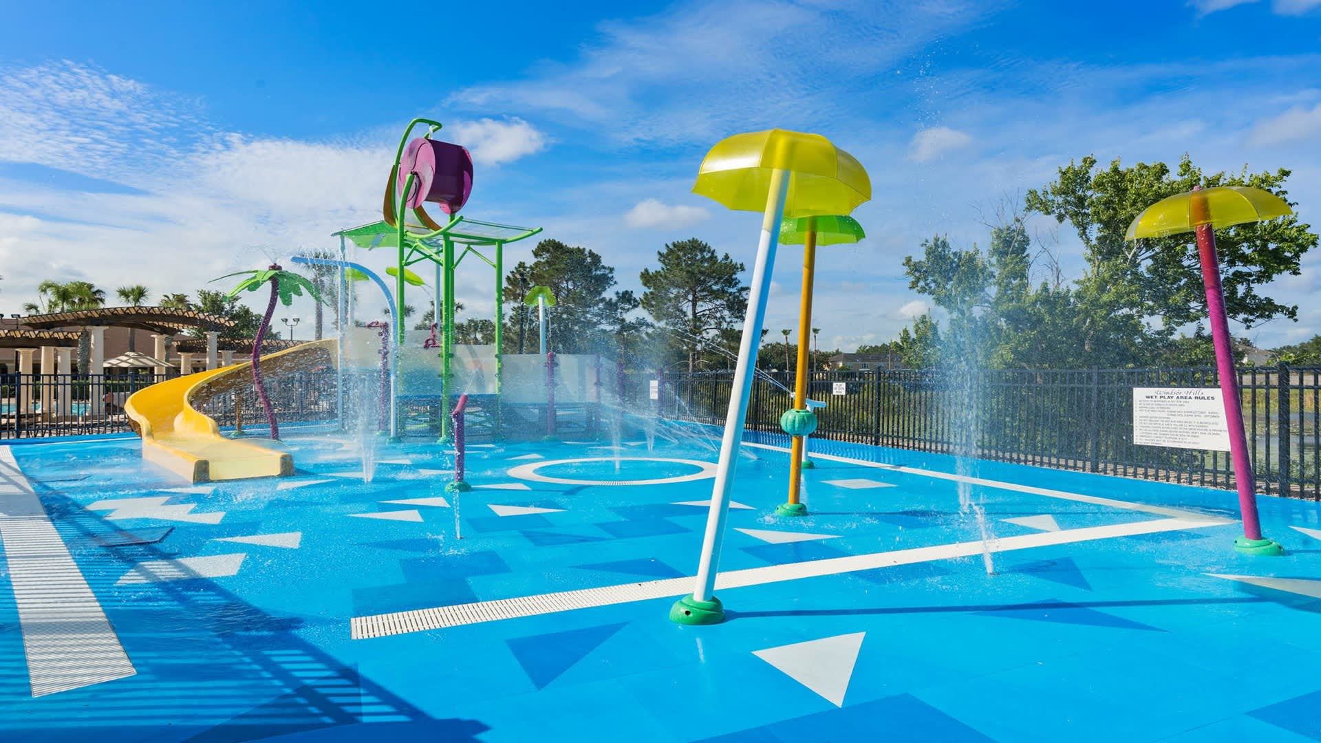 Colorful splash pad with water sprayers, mini slide, and fun for kids to enjoy
