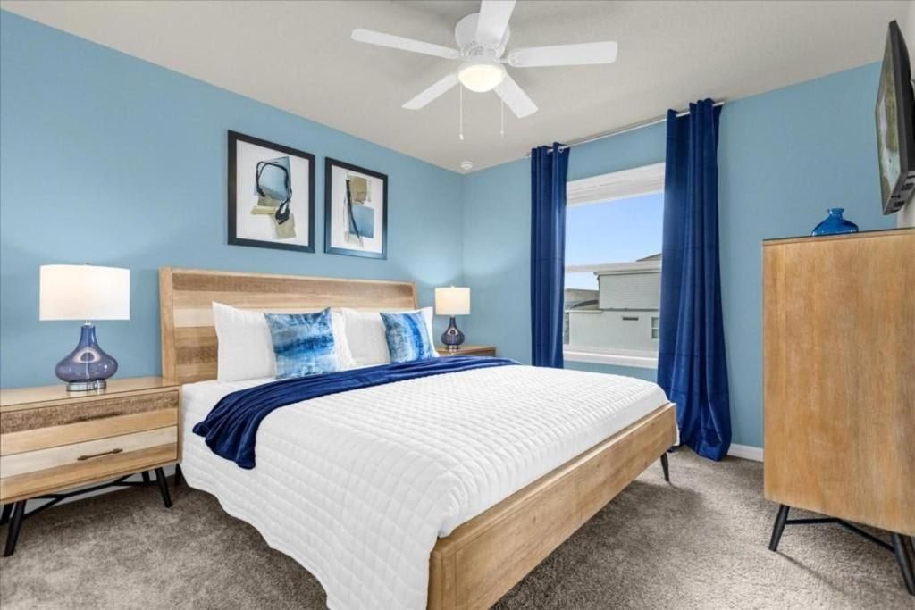 Bright and airy king bedroom with modern furnishings and calming blue accents.