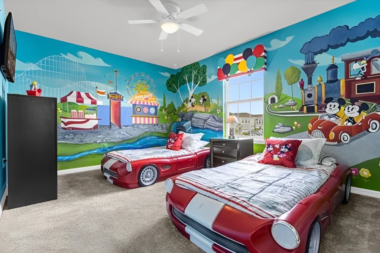 Whimsical carnival-themed room with car beds and vibrant amusement park murals.