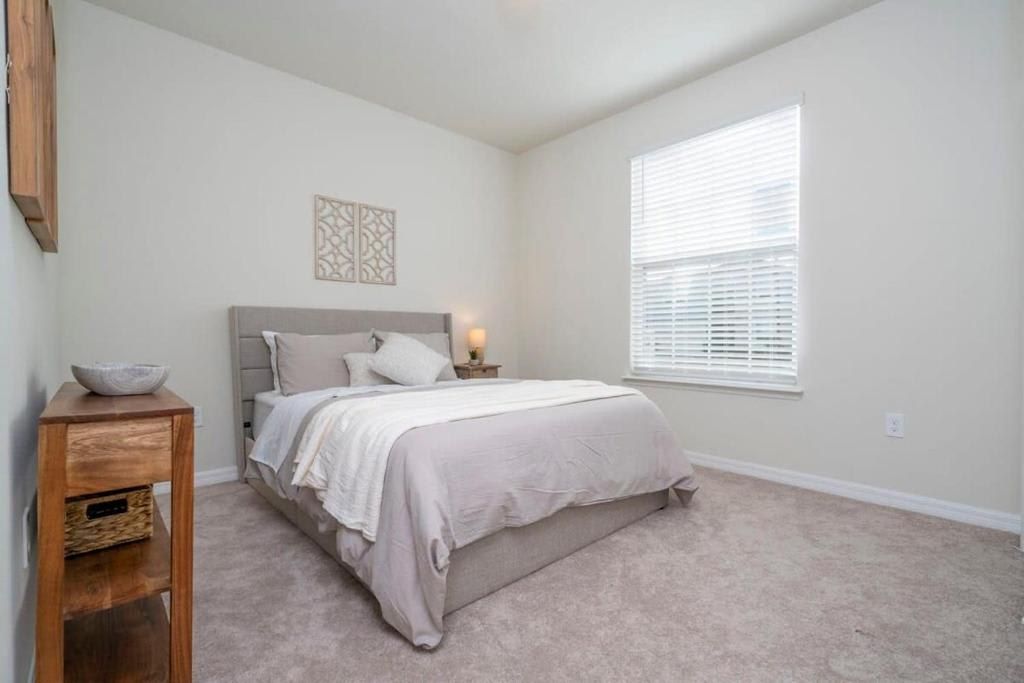 Serene and minimalist bedroom with soft bedding and natural light.