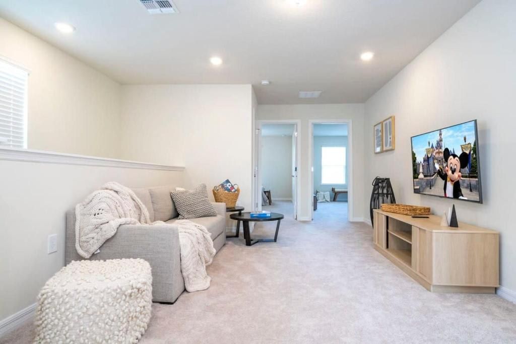 Relaxing living area with soft seating, TV, and a calm, neutral palette.