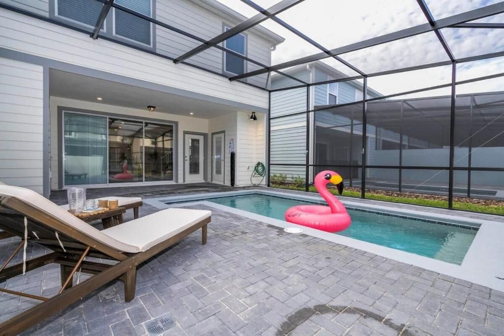 Chic screened patio with private pool, lounge chairs, and fun flamingo float.
