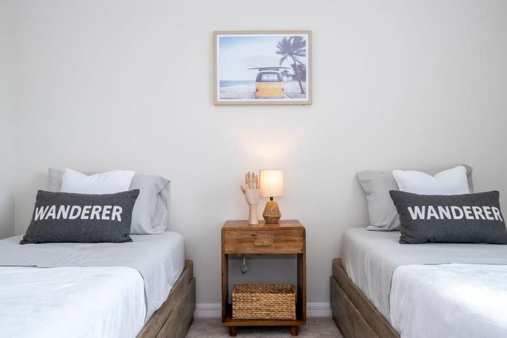 Charming twin bedroom with a wanderlust theme, featuring cozy beds and stylish decor.