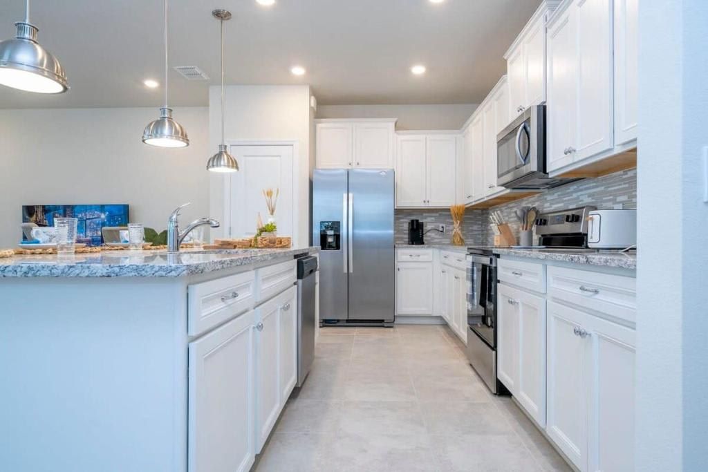 Modern kitchen with stainless steel appliances, sleek countertops, and ample space.