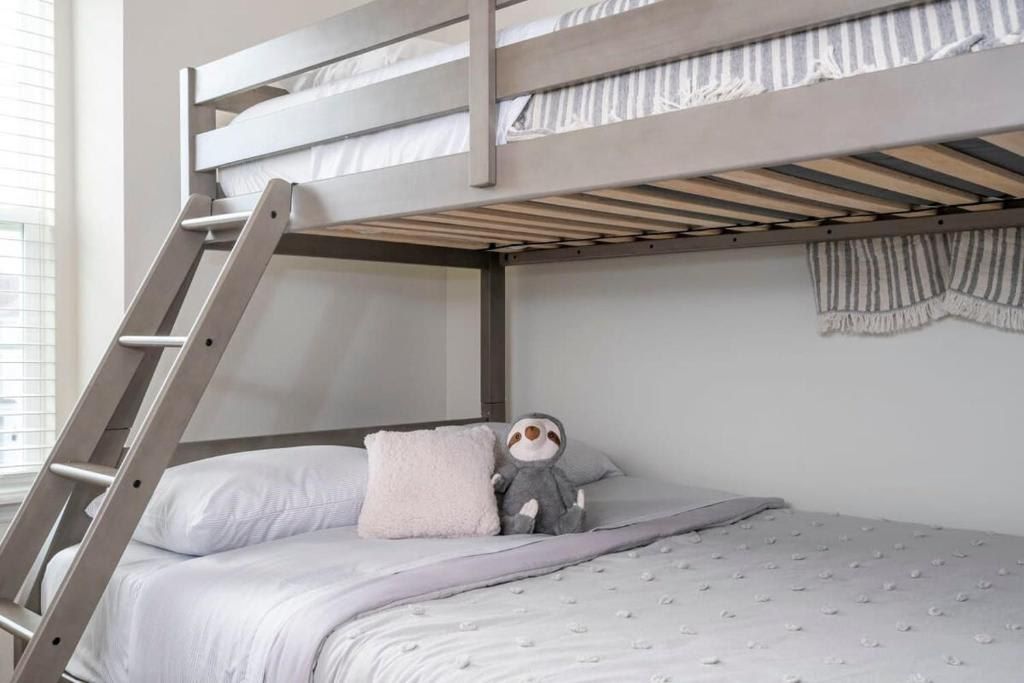 Cozy bunk bed with soft linens and a charming touch of playful decor.