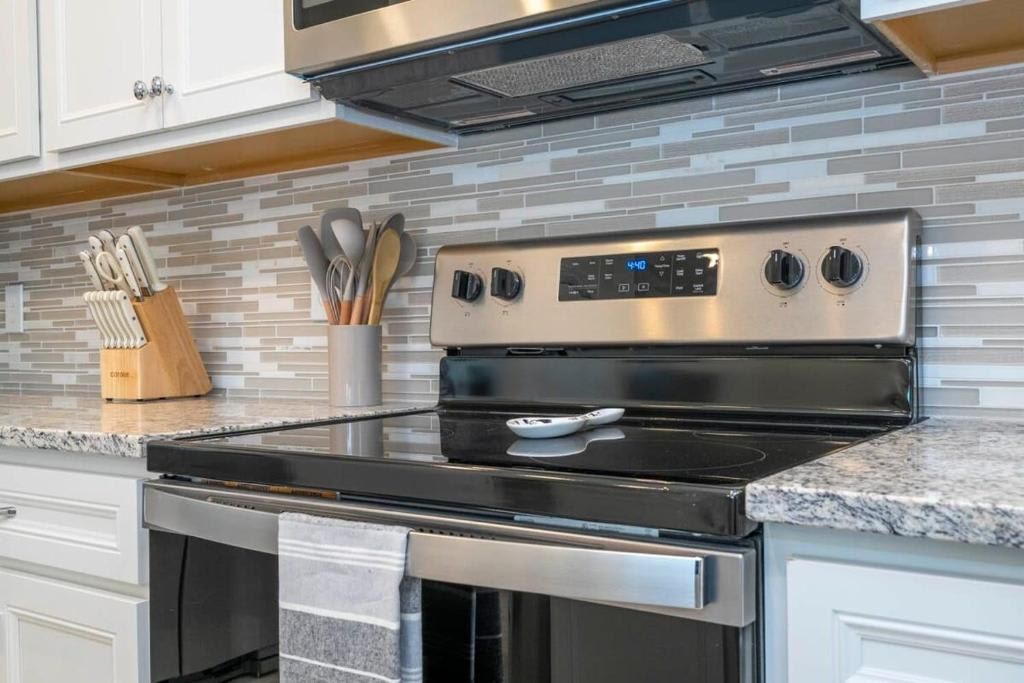 Modern kitchen with sleek stainless steel appliances and stylish backsplash.
