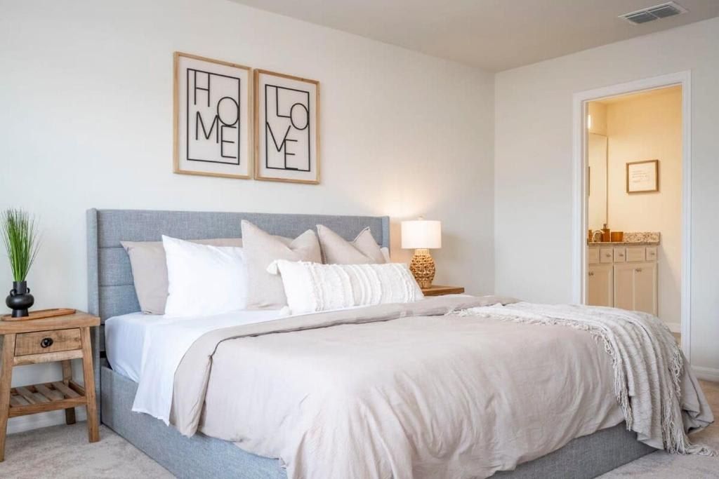 Serene king bedroom with plush bedding, ensuite bath, and calming neutral tones.