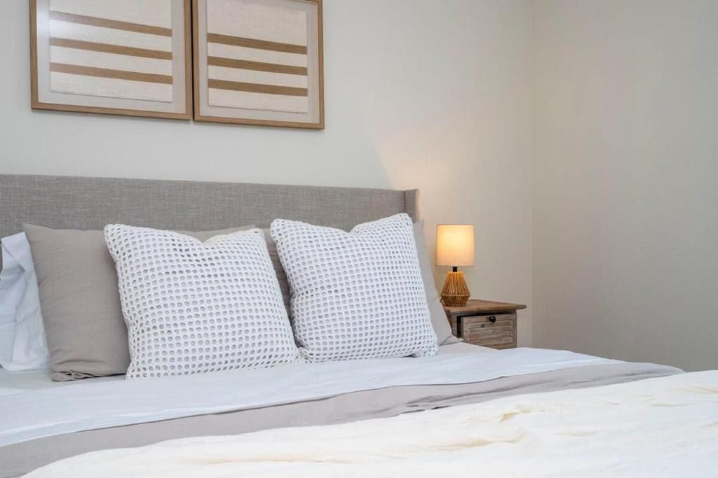 Cozy and modern bedroom with soft pillows, calming decor, and warm lighting.