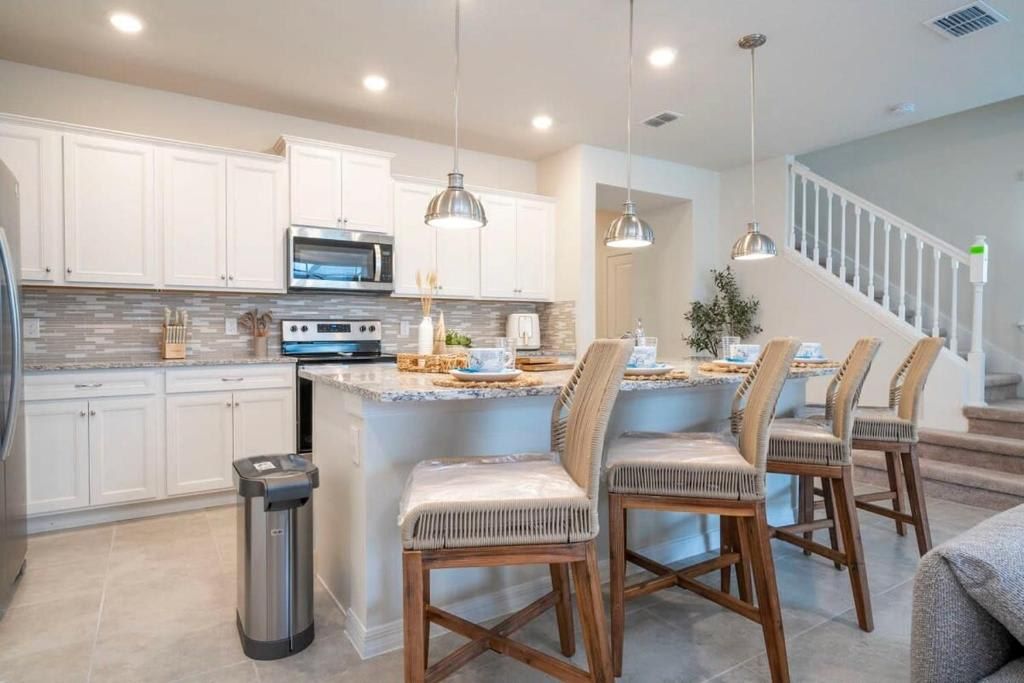 Modern kitchen with stainless steel appliances, island seating, and sleek design.