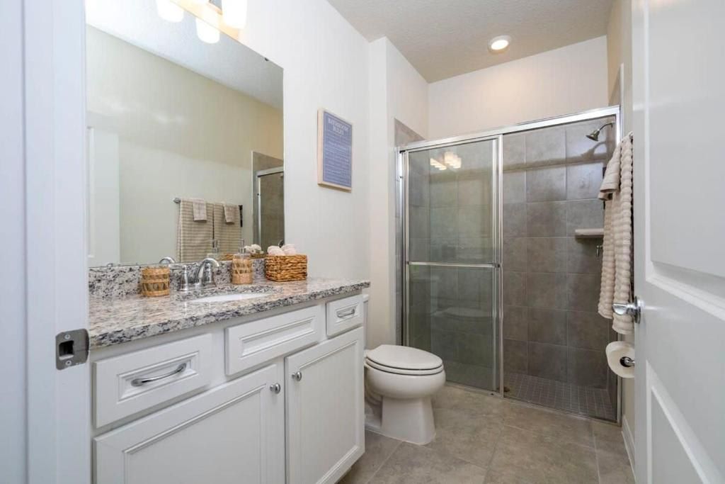 Stylish bathroom with granite countertop, glass walk-in shower, and modern finishes.