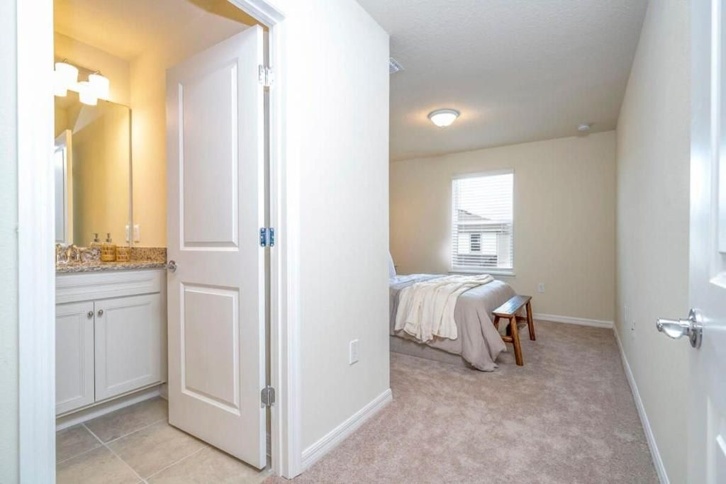 Bright and peaceful bedroom with ensuite bath, plush carpet, and cozy natural light.