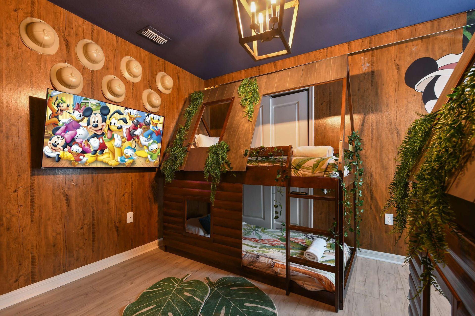 Cozy up in this jungle-themed bunk room with Mickey magic and tropical vibes!