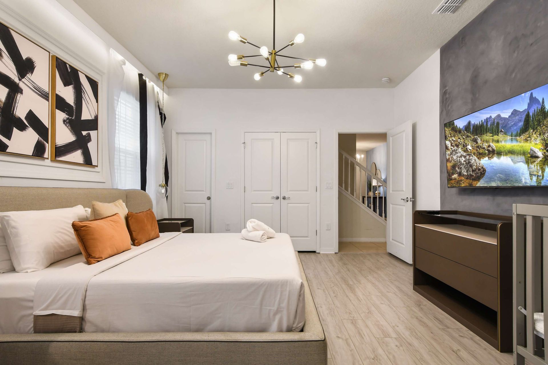 Spacious bedroom with sleek décor, smart TV, and cozy king-sized bed.