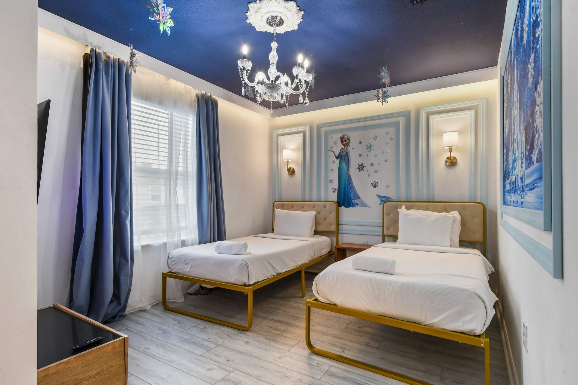 Enchanting princess-themed room with twin beds, chandelier lighting, and royal decor.