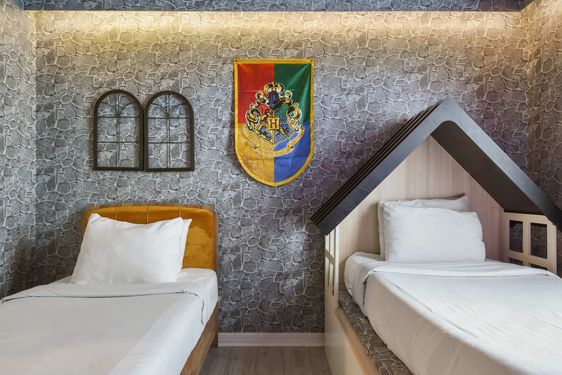 Charming wizard-inspired room with twin beds, themed wall art, and cozy nook.