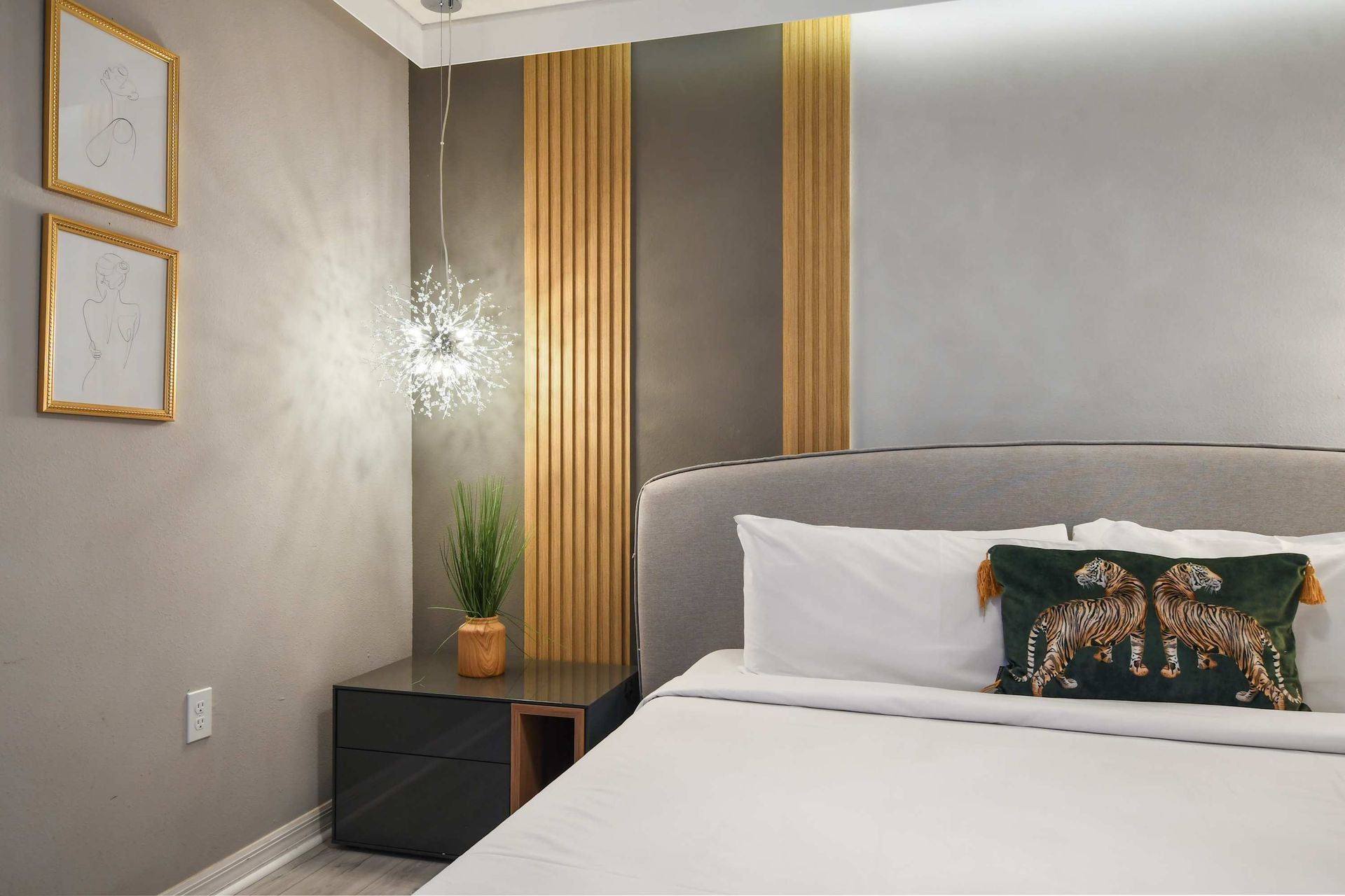 Sophisticated bedroom with gold accents, designer lighting, and a luxe king bed.