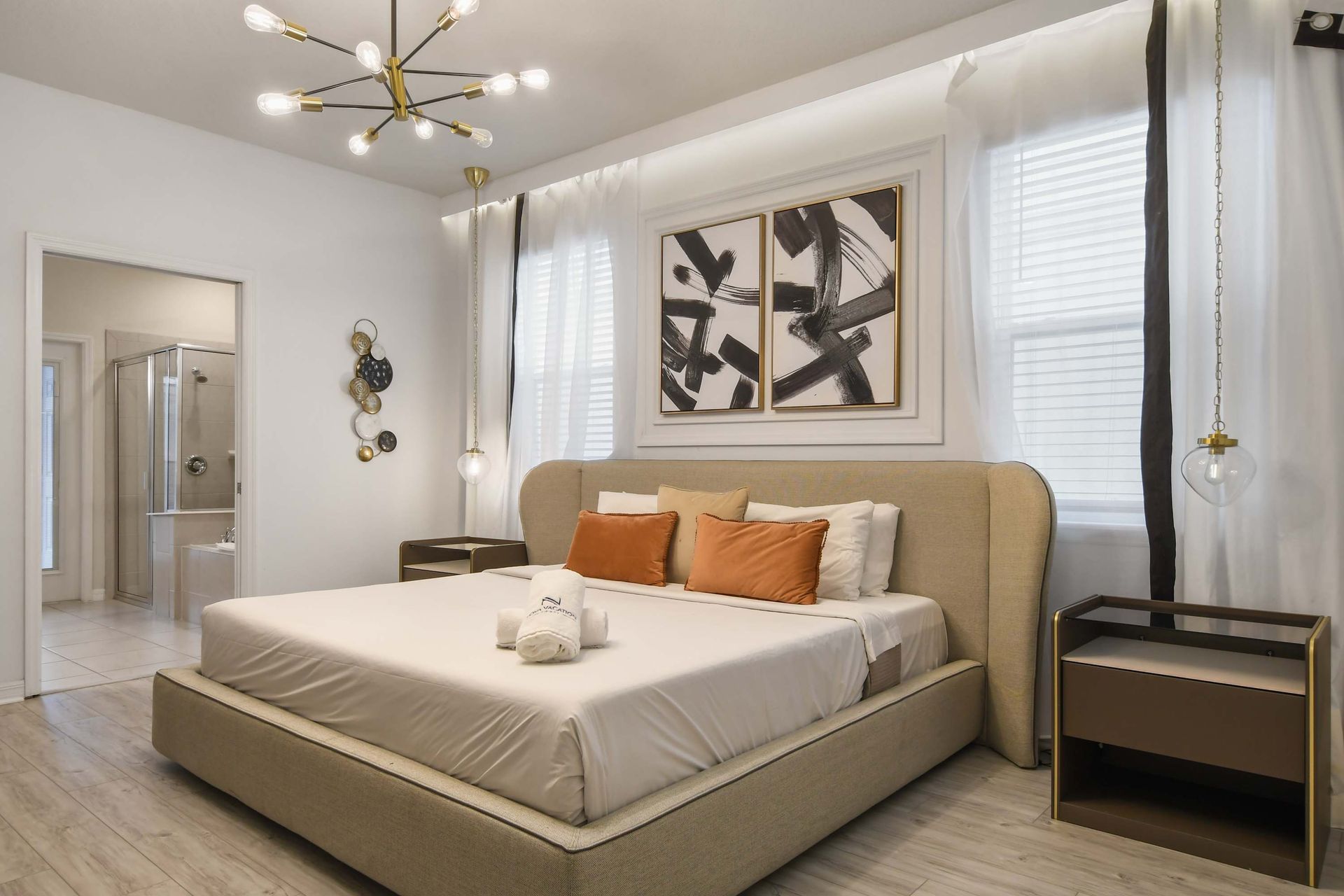 Elegant bedroom with modern lighting, plush king bed, and private en-suite bath.
