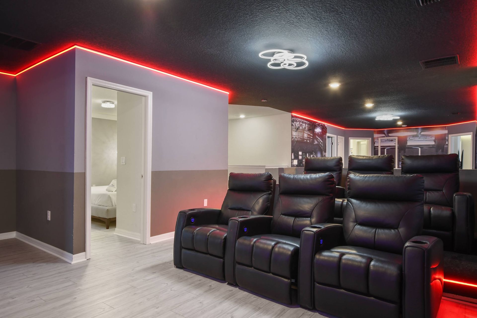 Private cinema room with plush recliners, glowing LED trim, and surround sound.