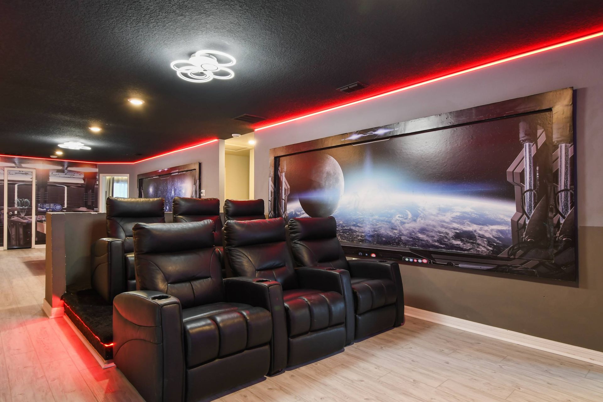 Epic home theater with leather recliners, LED lighting, and immersive space theme.