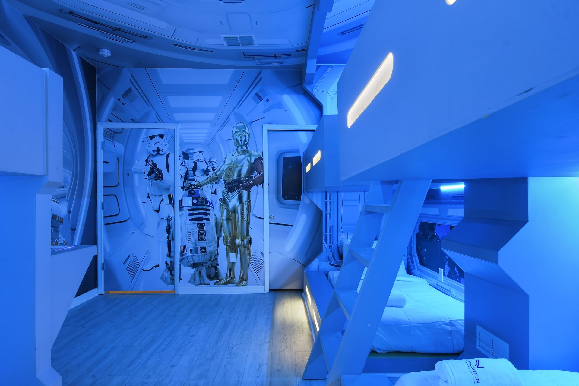 Futuristic bunk room with glowing lights, space-themed design, and custom beds.
