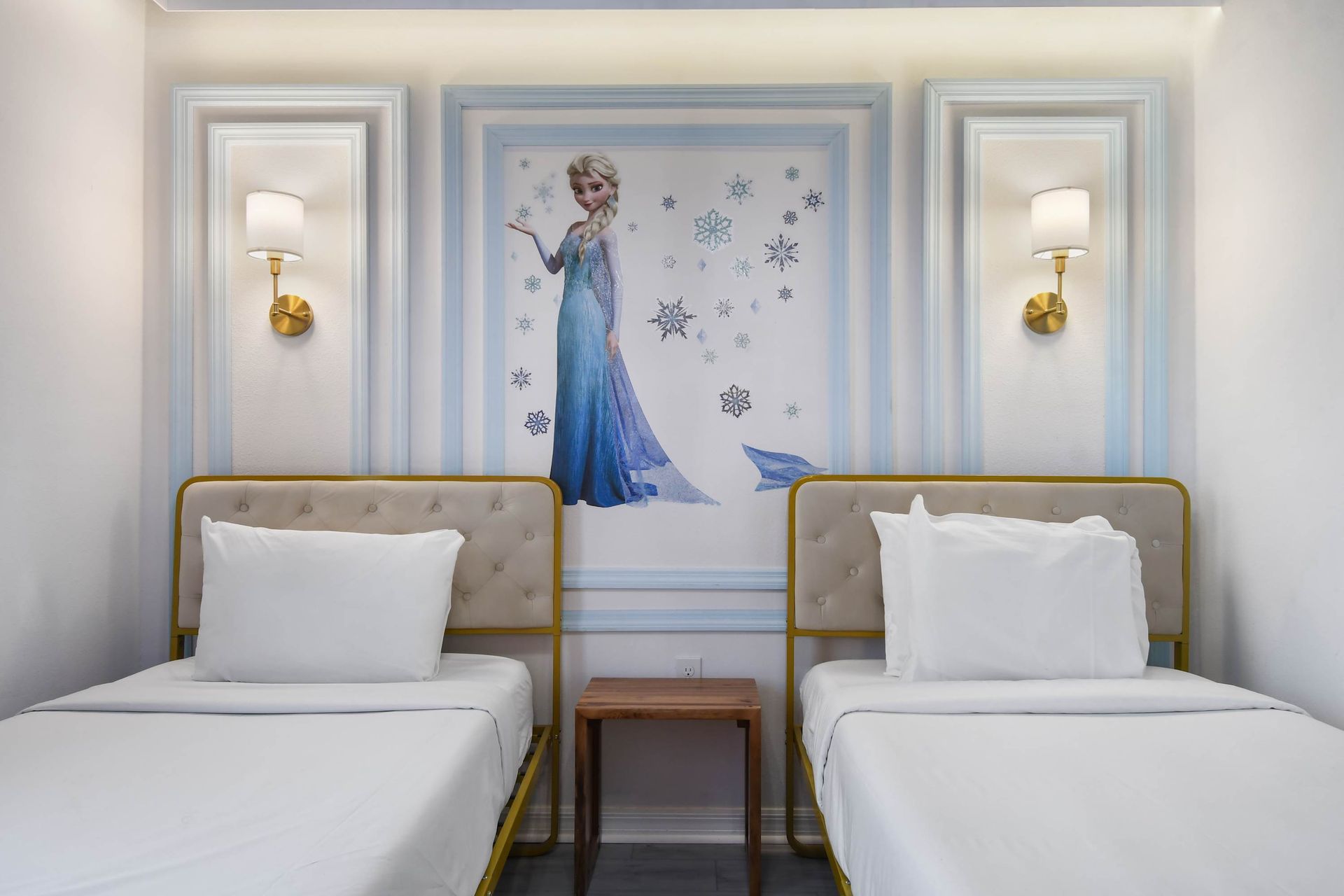 Charming Frozen-themed room with twin beds, snowflake details, and soft lighting.